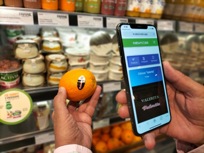 Hombre escaneando una naranja con Naturcode en el supermercado